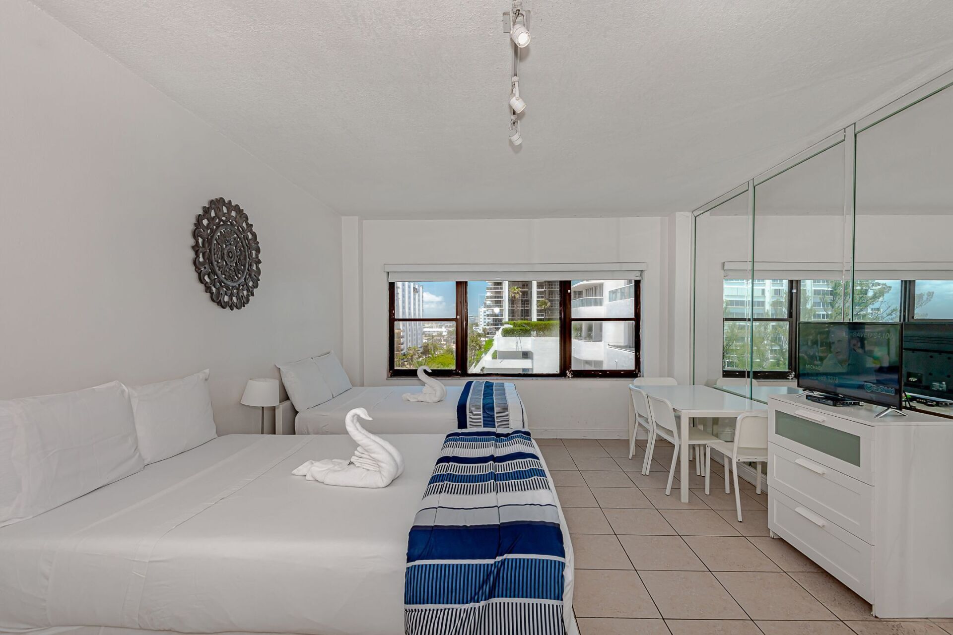 A hotel room with two beds , a table and chairs.