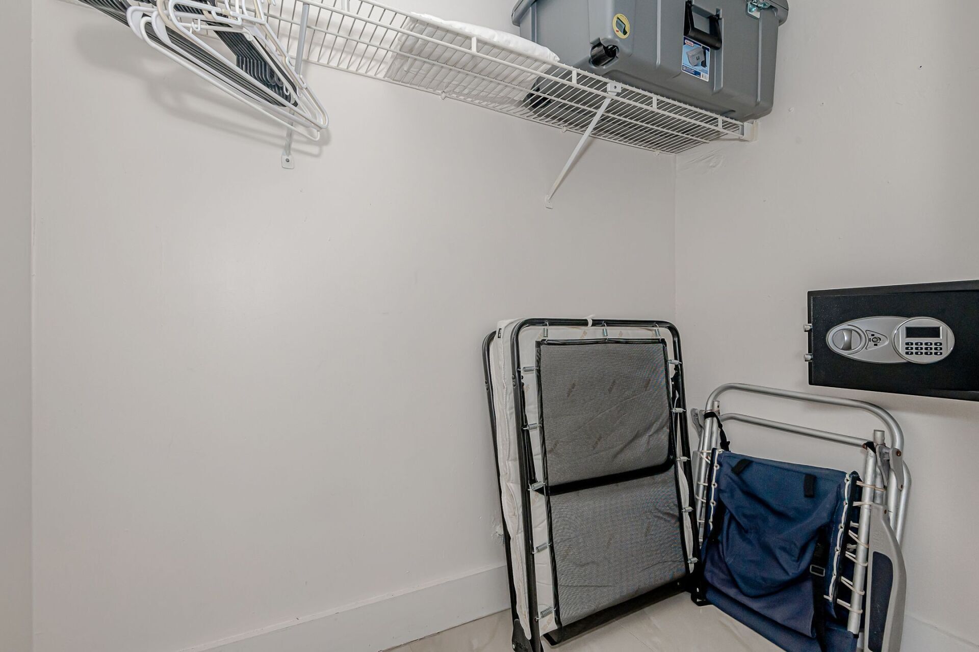A closet with a folding bed and a safe.