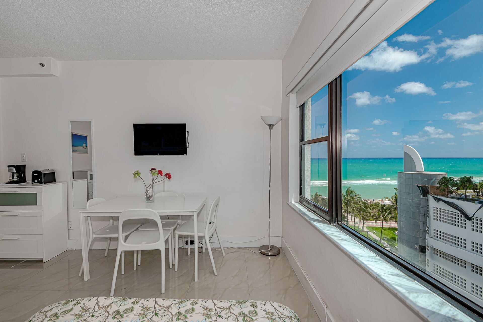 A living room with a table and chairs and a view of the ocean.