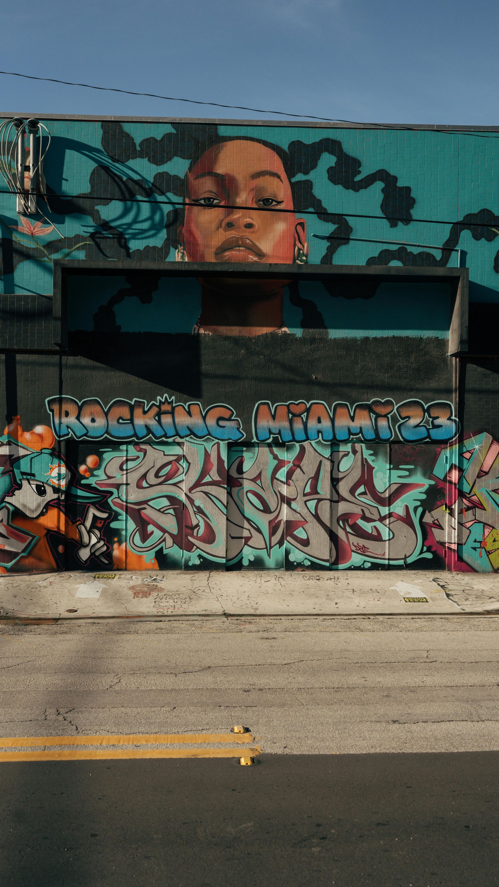 A large mural of a woman is on the side of a building.