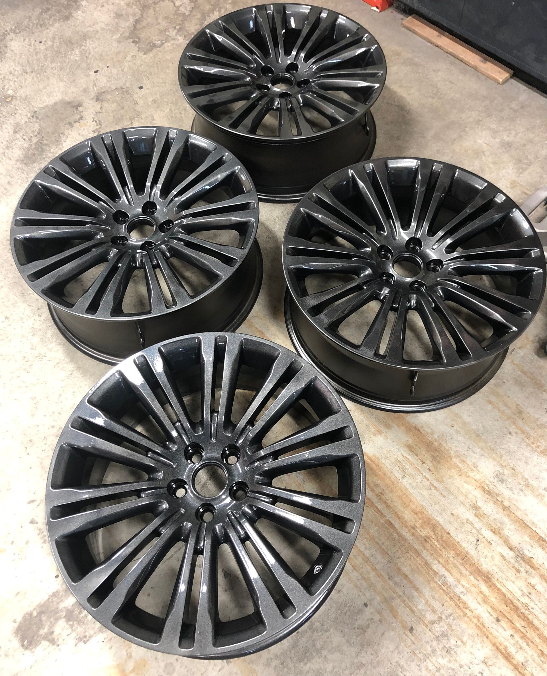 Quatre roues noires sont posées sur un sol en béton.