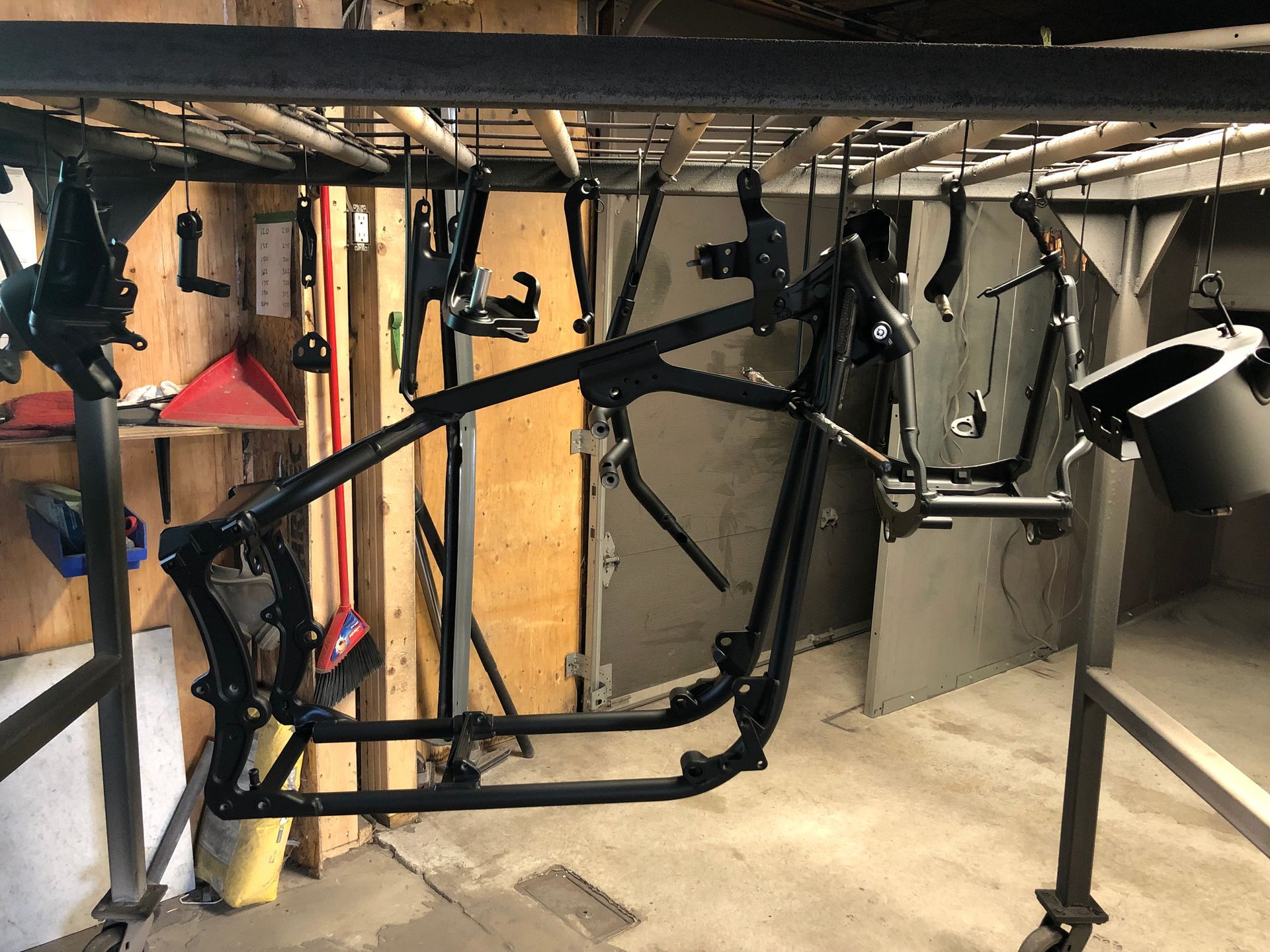 A motorcycle frame is sitting on a rack in a room.