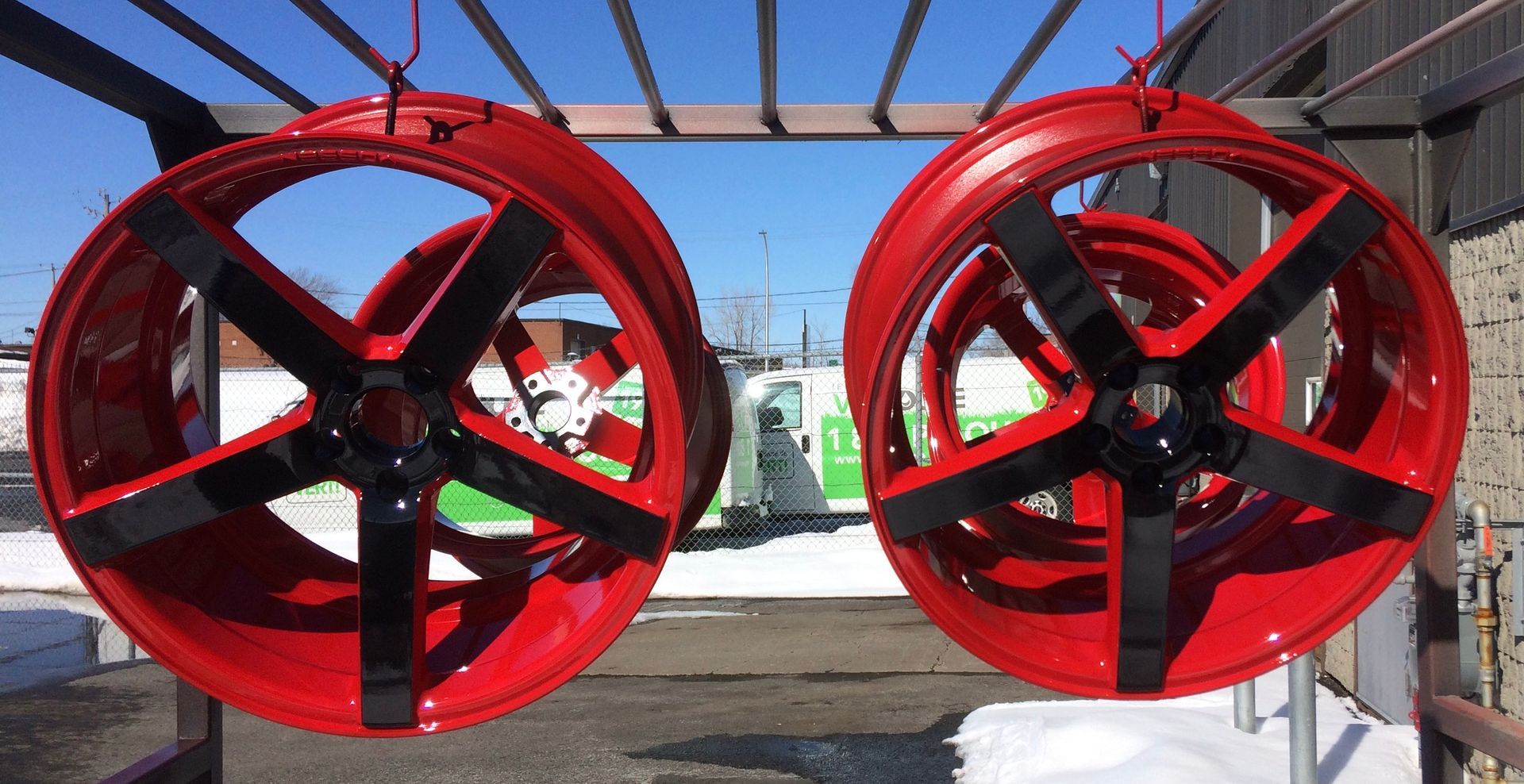 Une paire de roues rouges est suspendue à un support.