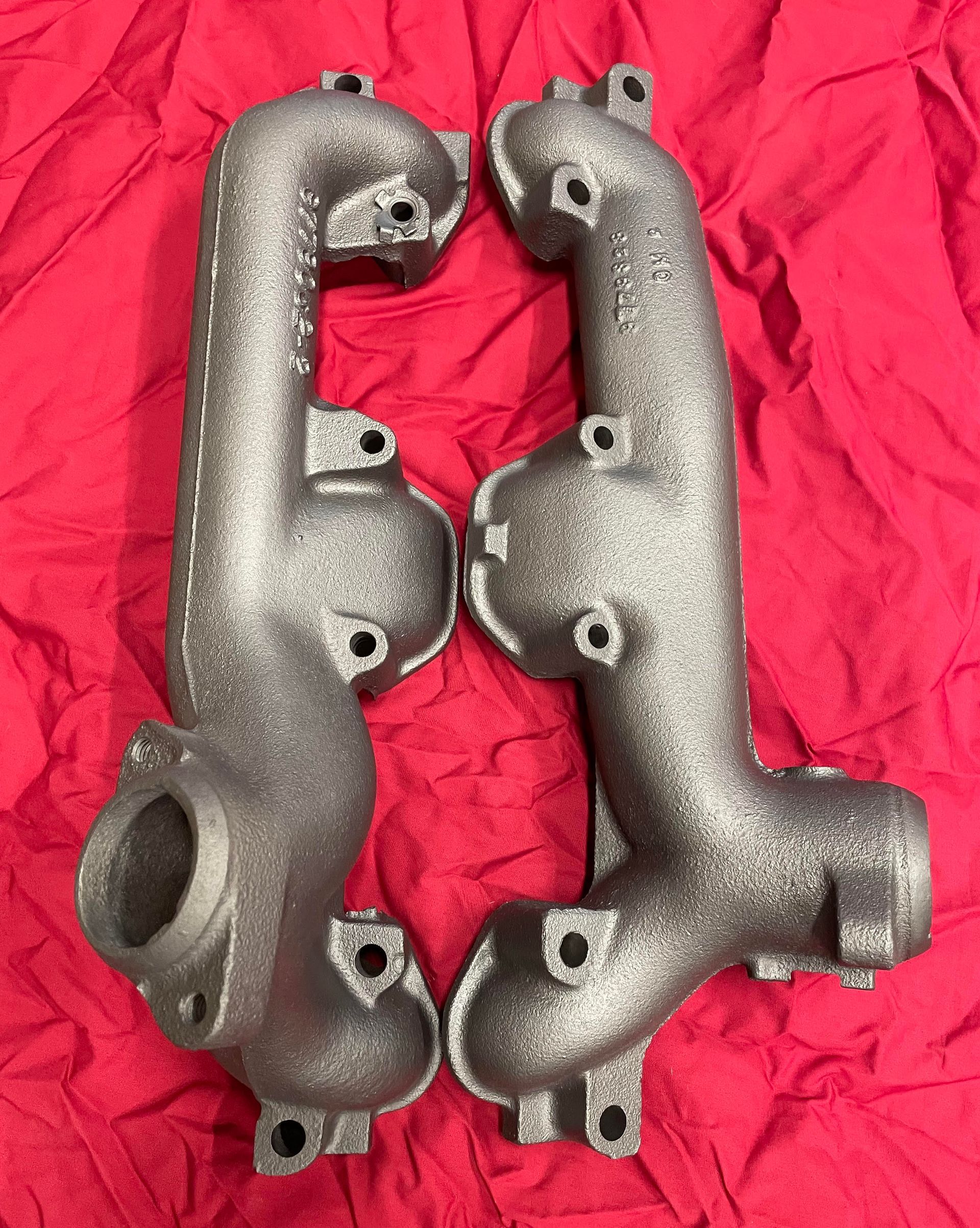 Une paire de collecteurs d'échappement sur un tissu rouge