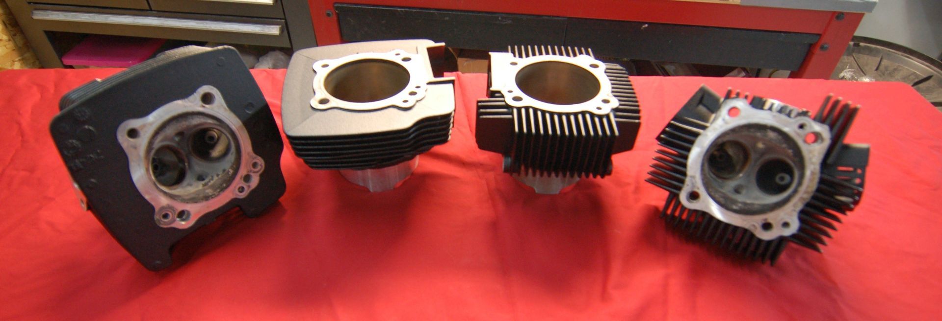 Quatre cylindres sont posés sur une nappe rouge sur une table