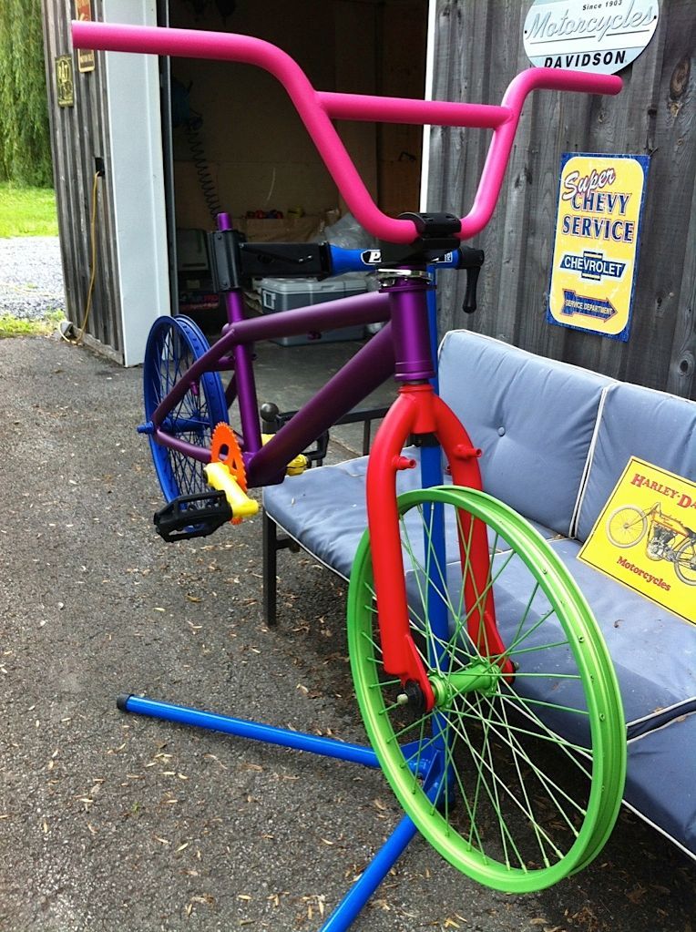 Un vélo coloré est assis sur un banc devant un panneau indiquant 5400 service de vol