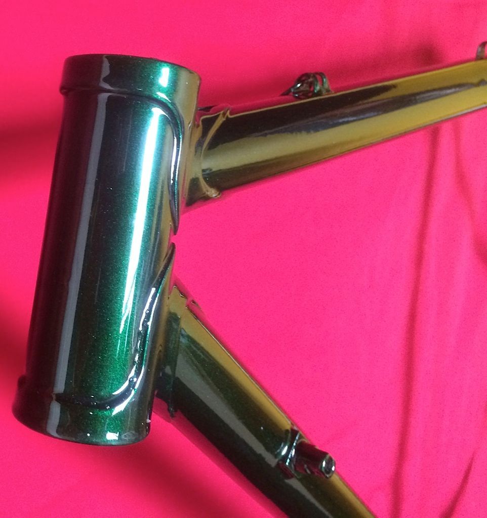 Un cadre de vélo vert est posé sur un tissu rouge