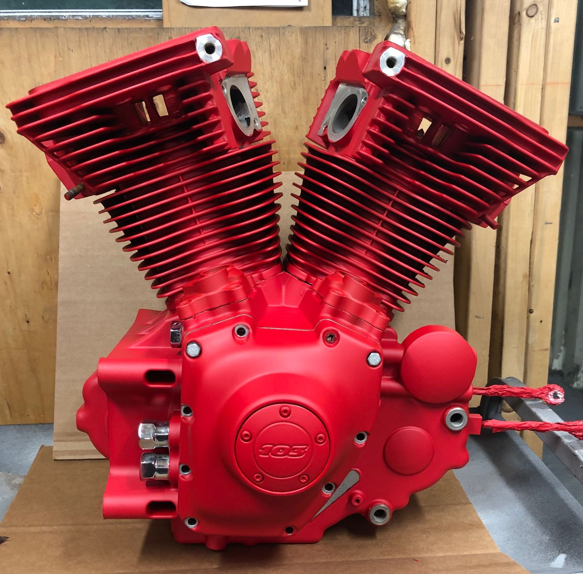 Un moteur de moto rouge est posé sur une boîte en carton