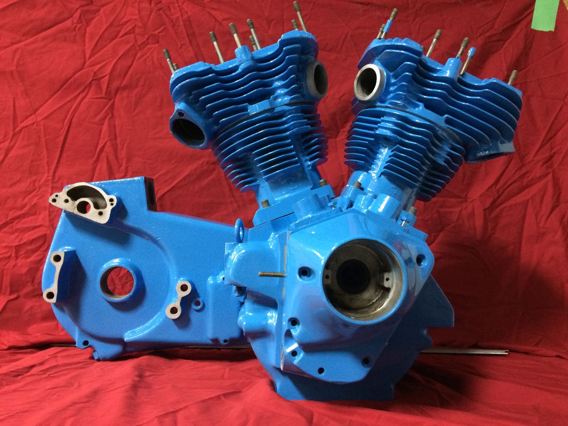 Un moteur de moto bleu est posé sur un tissu rouge