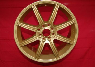 Une roue en or repose sur une surface rouge