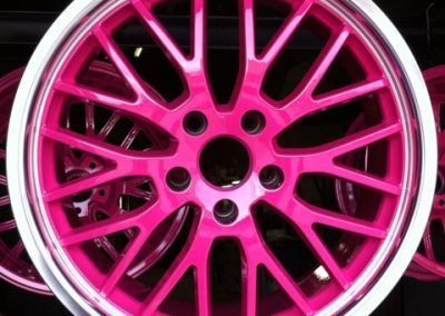 Un gros plan d'une roue rose avec une jante argentée