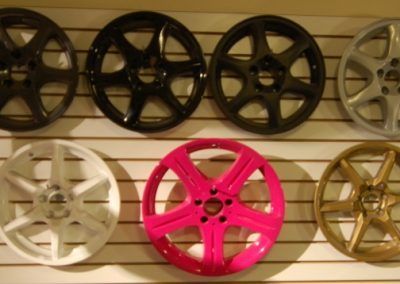 Un tas de roues de différentes couleurs sont accrochées à un mur