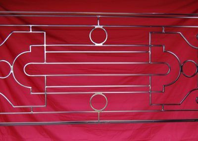 Une balustrade en acier inoxydable est posée sur un tissu rouge.