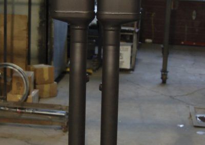 Two black pipes are sitting next to each other in a room.