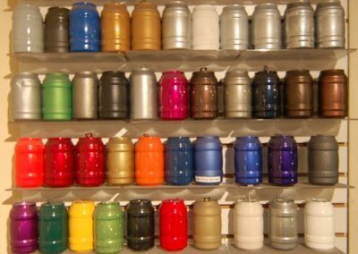 Une étagère remplie de nombreux barils de couleurs différentes