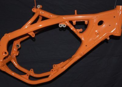 Un gros plan d'un cadre de moto orange sur fond noir