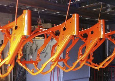 Un tas de cadres de motos orange suspendus au plafond