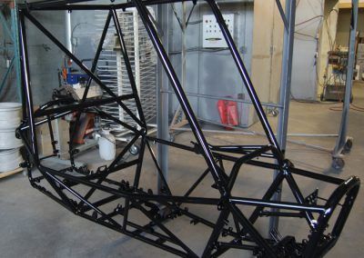 Un cadre en métal noir est posé sur le sol dans un garage