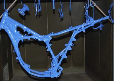 Un cadre de moto bleu est accroché à un support.