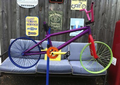 Un vélo violet est assis sur un canapé à côté d'un panneau indiquant « service Chevrolet »