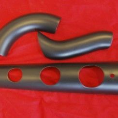 Un tuyau noir avec des trous est posé sur un tissu rouge.