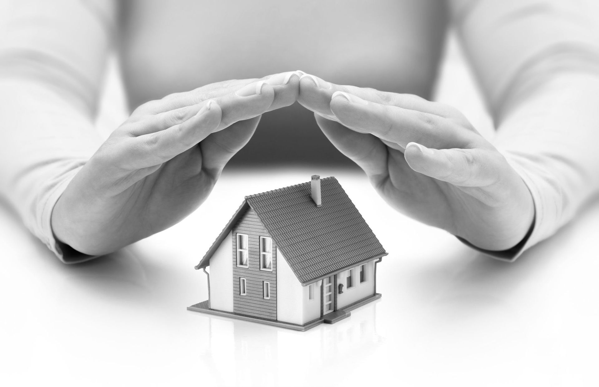 A person is holding a small house in their hands.