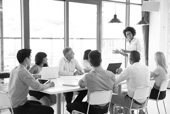 A group of people are sitting around a table having a meeting.