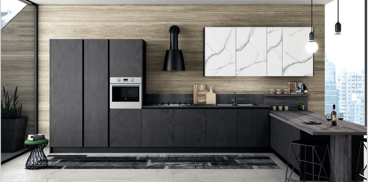 Una cucina con mobili neri e un forno sul piano cottura