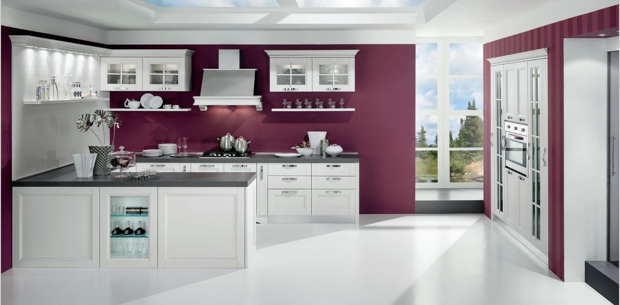 Una cucina con mobili bianchi e pareti rosse