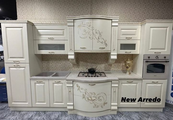 Una cucina con mobili bianchi e un piano cottura con forno.