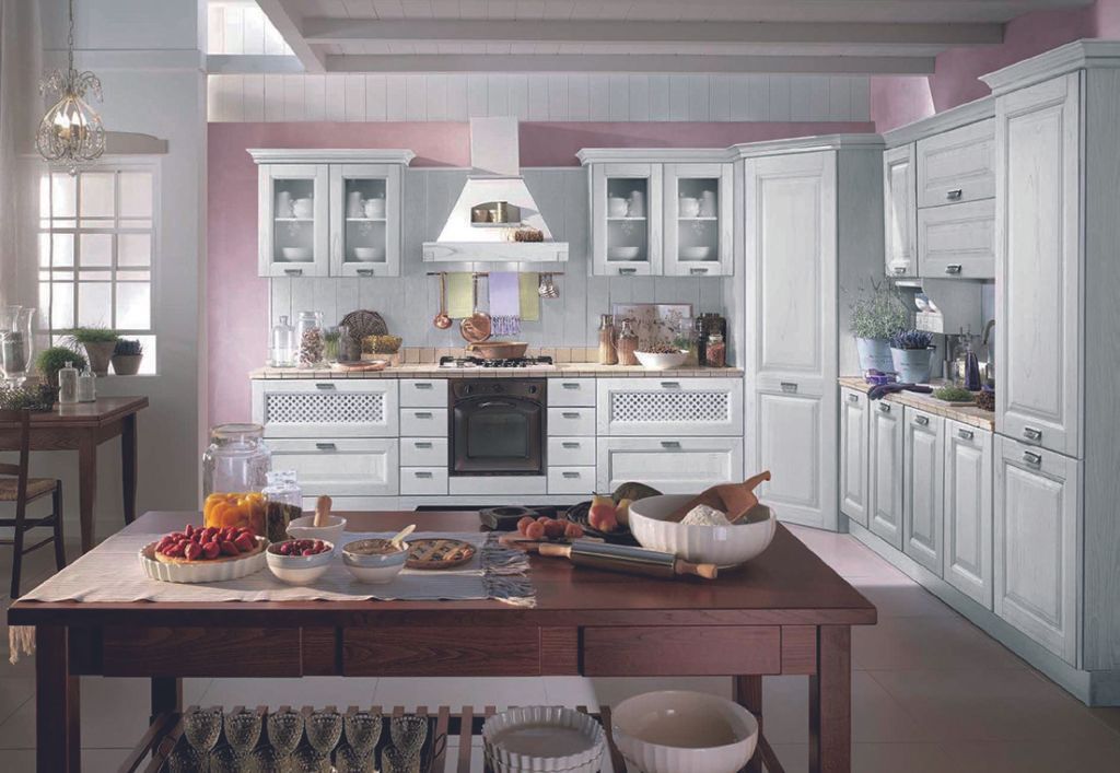 Una cucina con mobili bianchi e un tavolo di legno