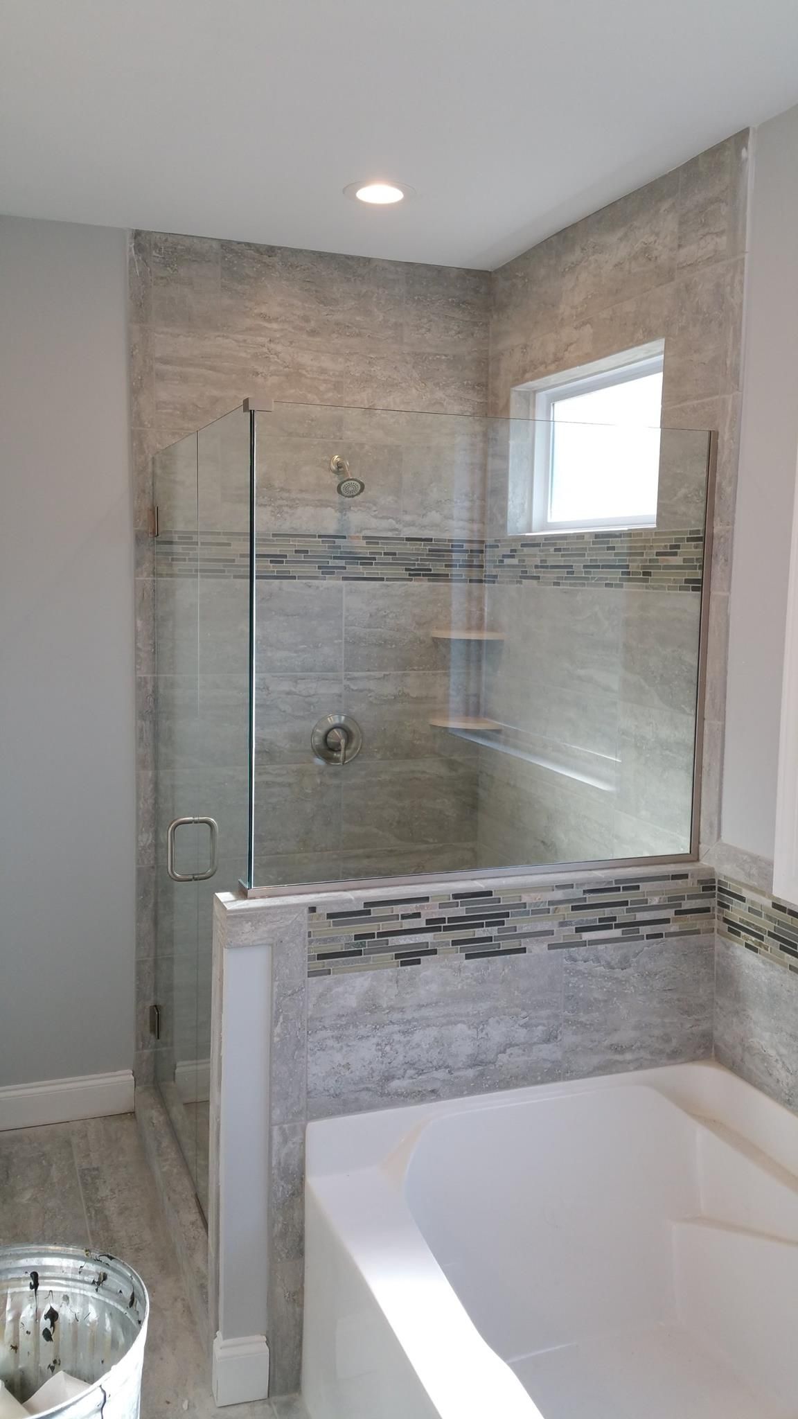 A bathroom with a walk in shower and a bathtub