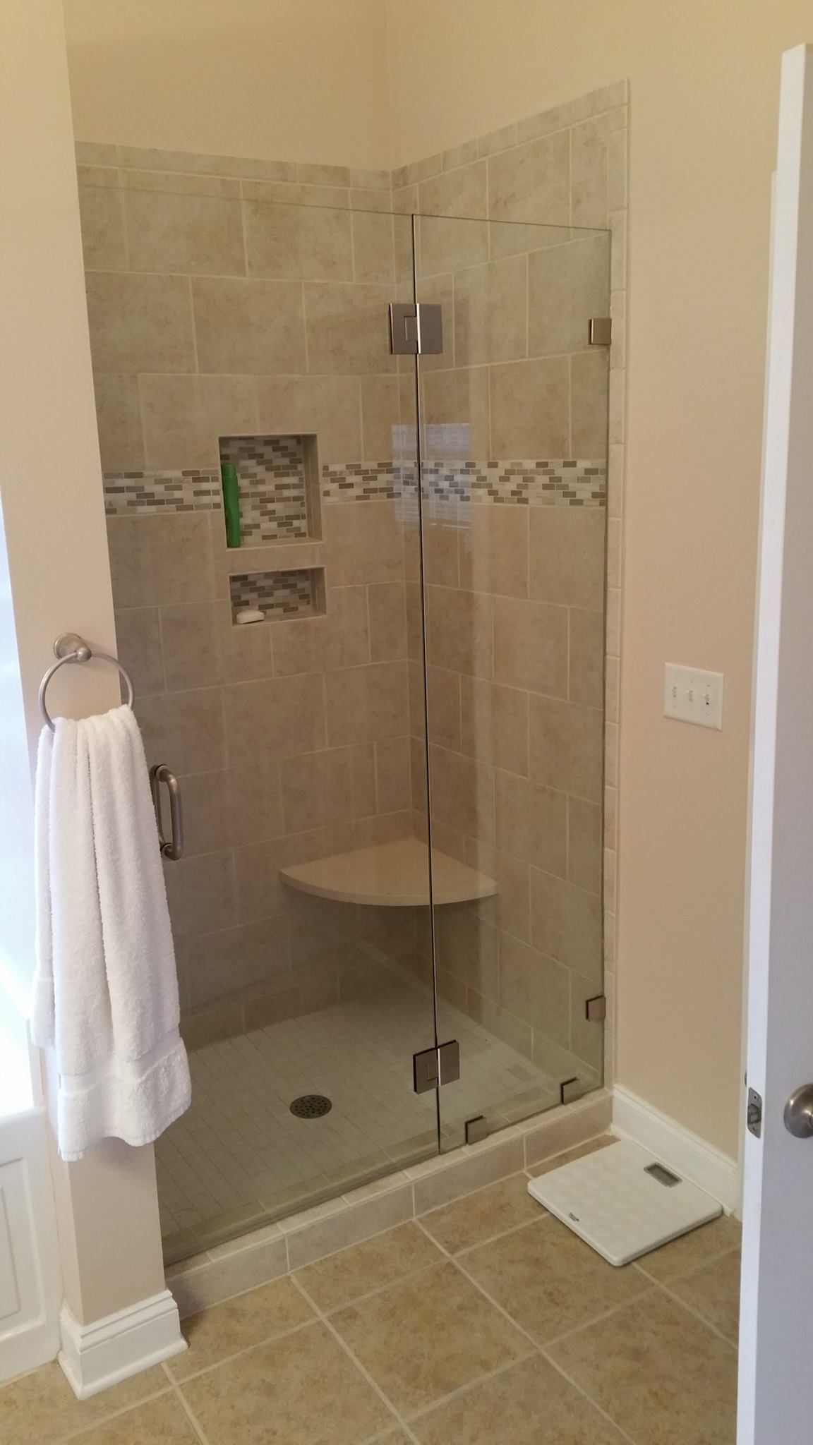 A bathroom with a walk in shower with a glass door