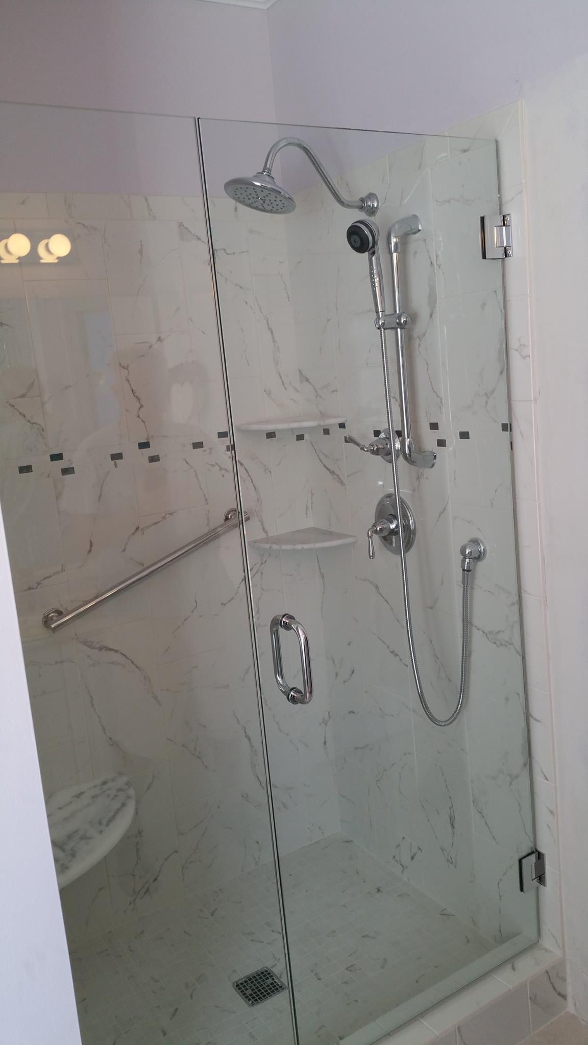 A shower stall with a glass door and a shower head