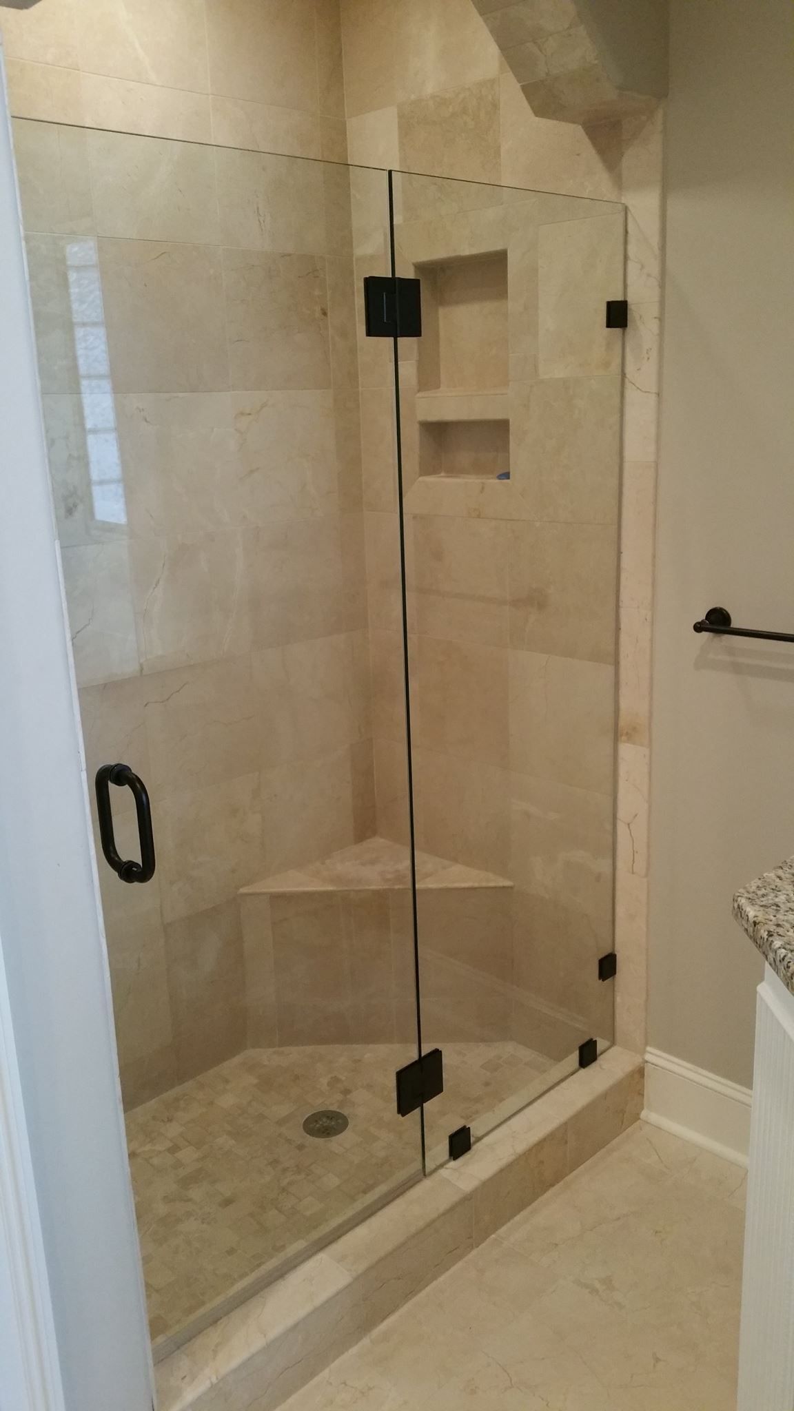 A bathroom with a walk in shower with a glass door