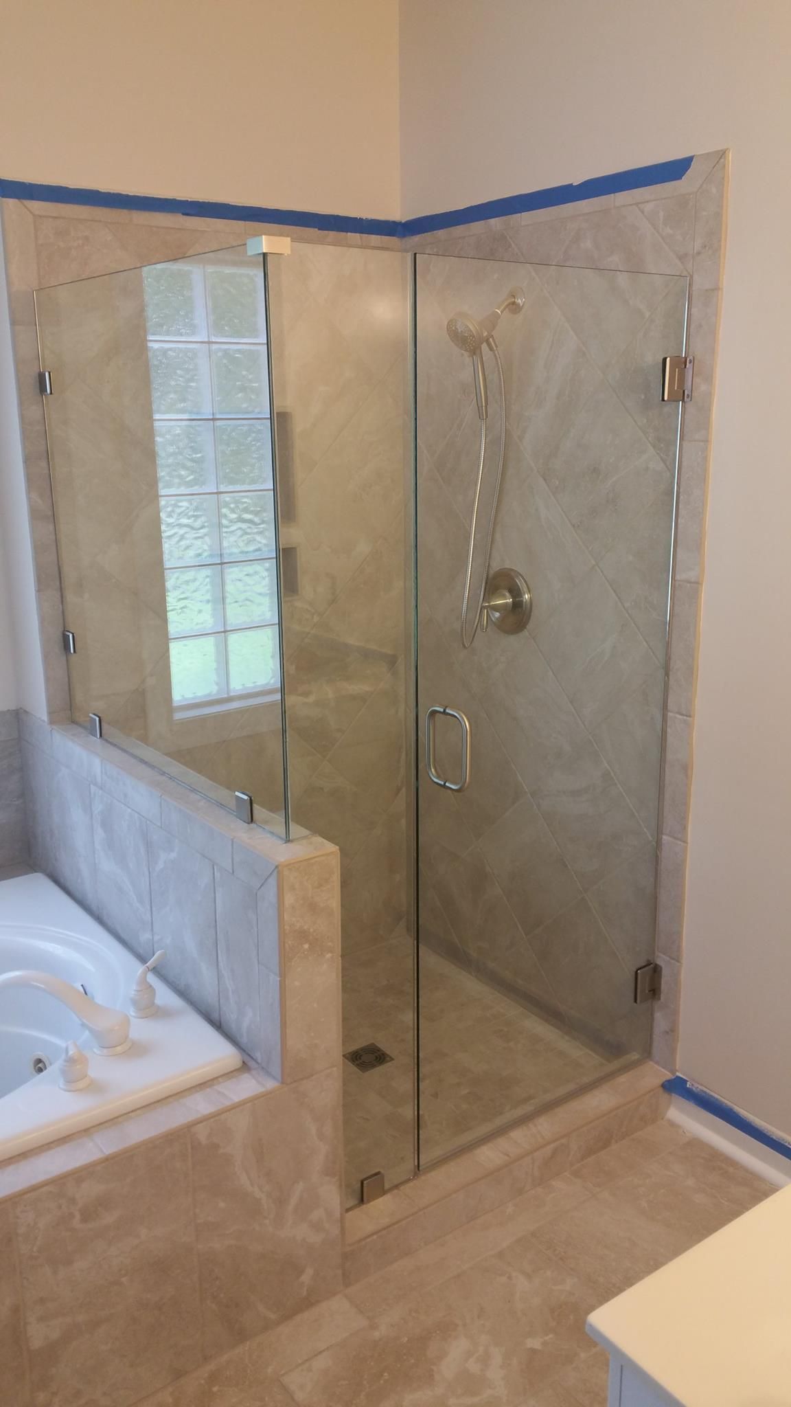 A bathroom with a walk in shower and a bathtub