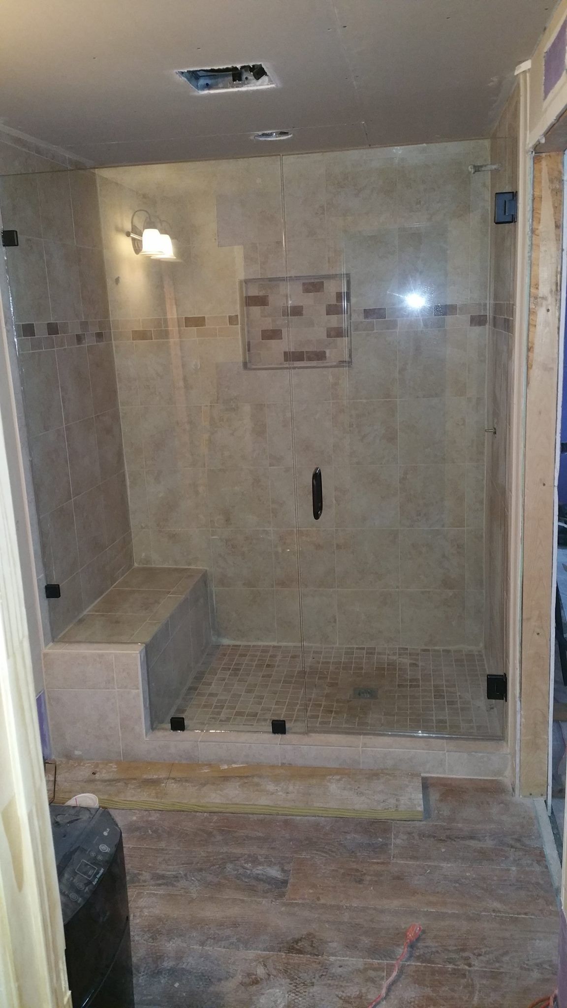 A bathroom with a walk in shower with a glass door
