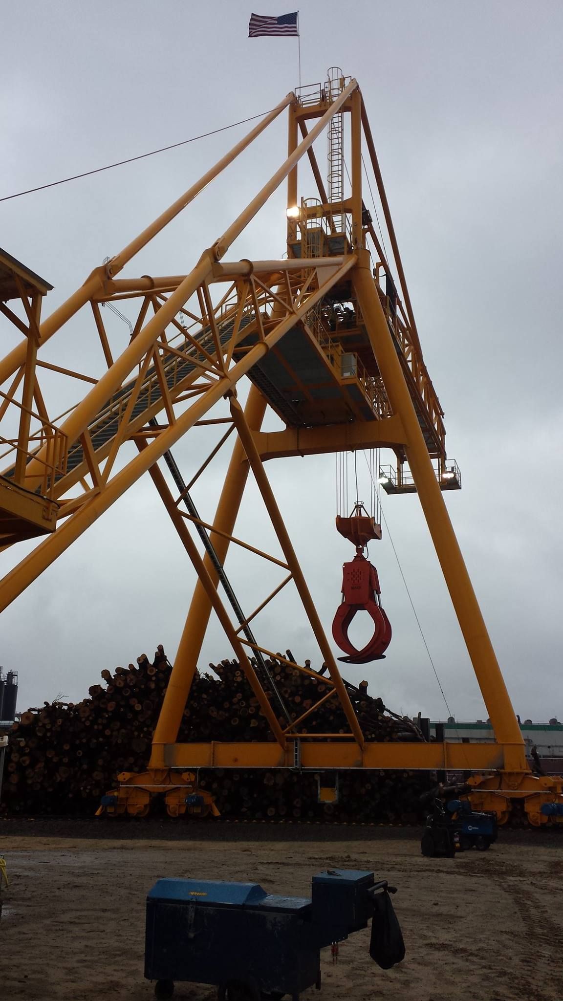 A large yellow crane with a flag on top of it