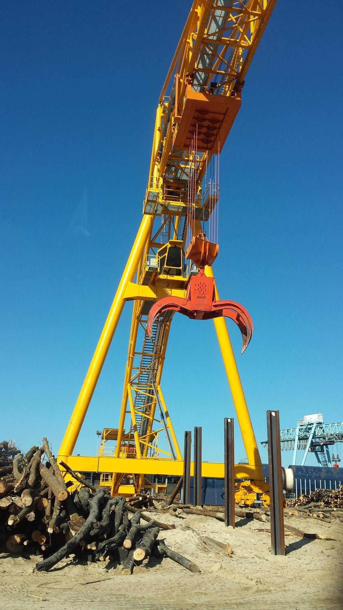 A large yellow crane with a red claw on top of it