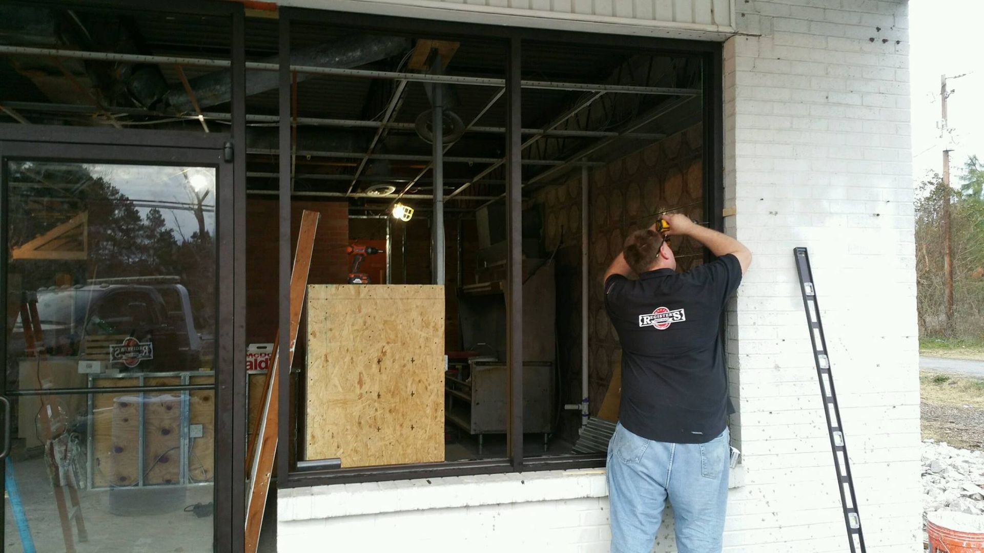 A man in a black shirt is standing in front of a window