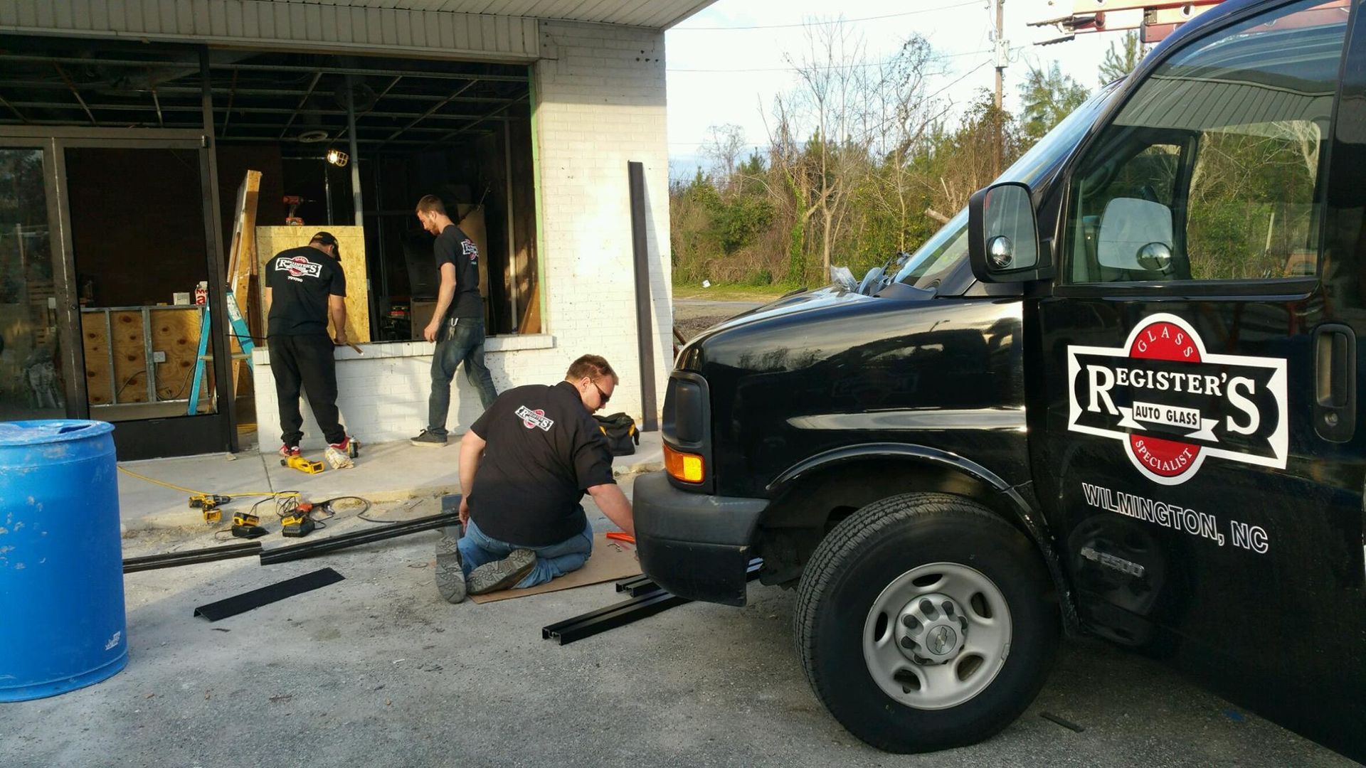 A black van with the word register 's on the side is parked in front of a building