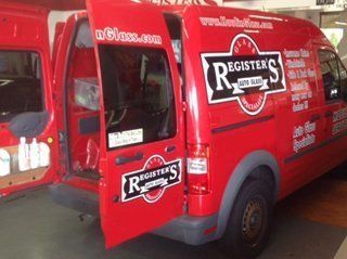 A red van that says register 's on the side