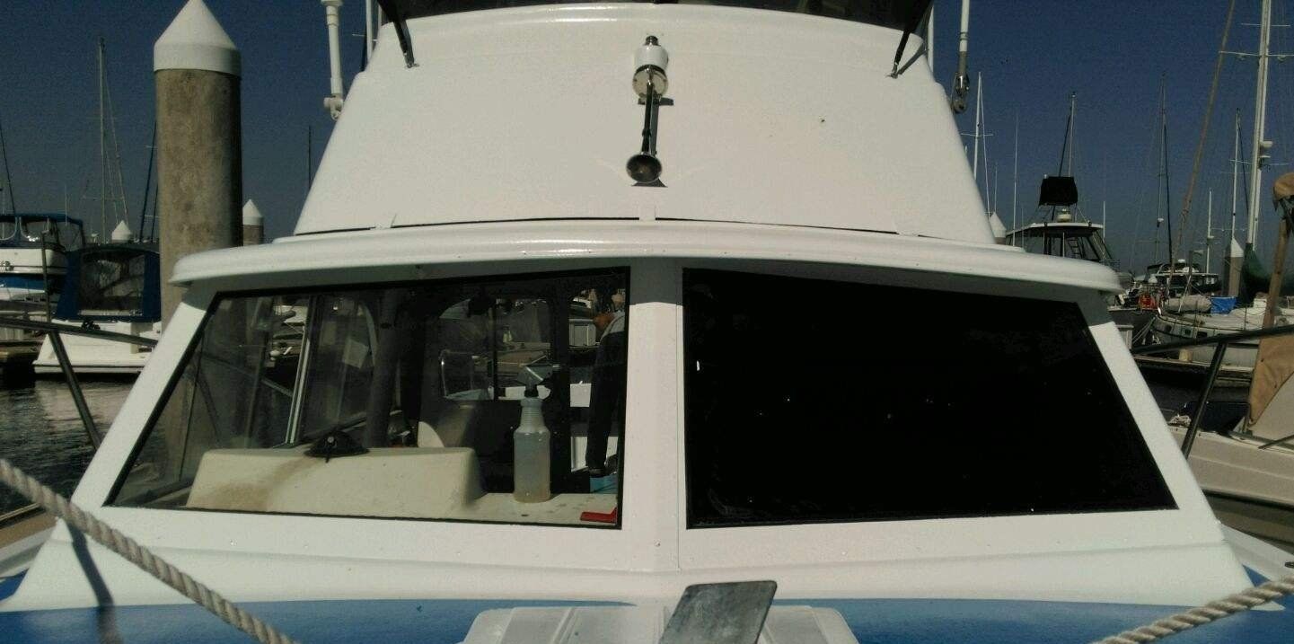 A blue and white boat is docked at a marina