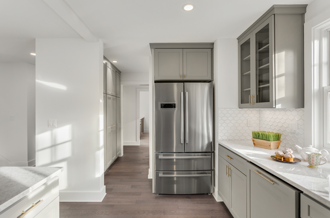 A kitchen with stainless steel appliances and gray cabinets