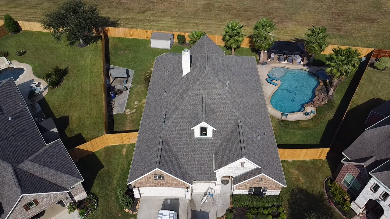 An aerial view of a house with a pool in the backyard.