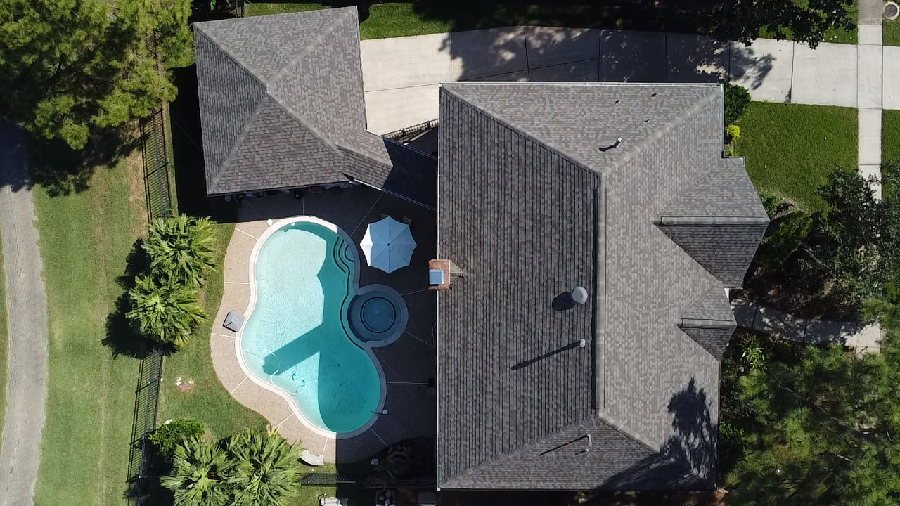 An aerial view of a house with a pool and umbrellas.