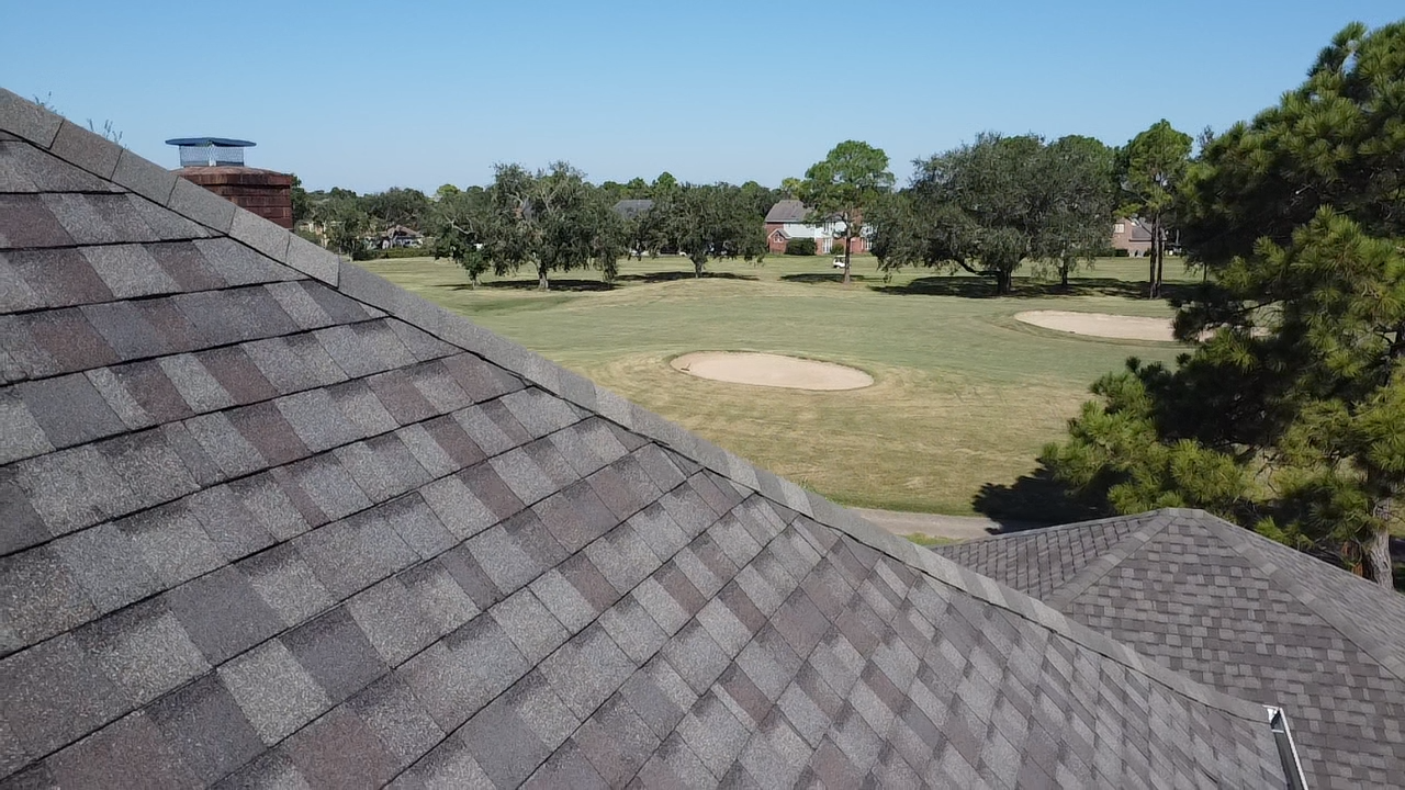 An aerial view of a roof with a golf course in the background