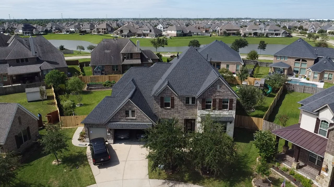 An aerial view of a residential area with a large house in the middle.