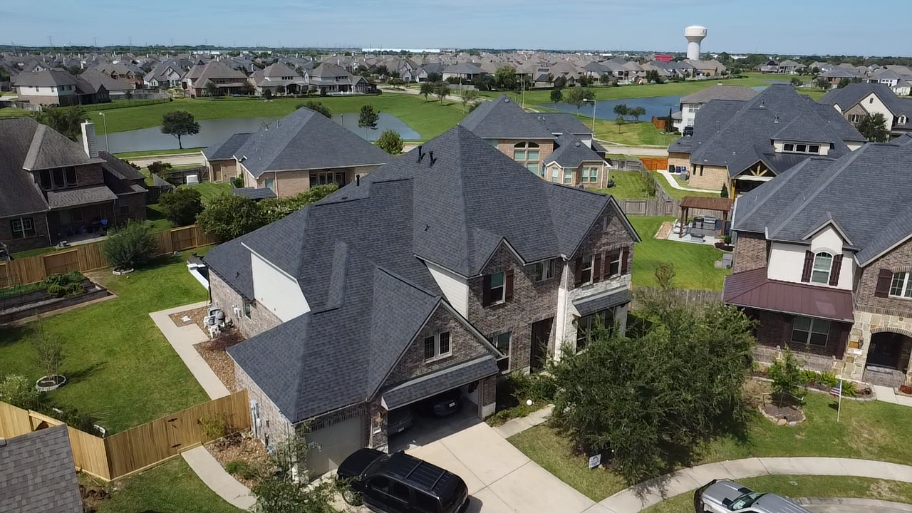 An aerial view of a residential neighborhood with a large house in the middle