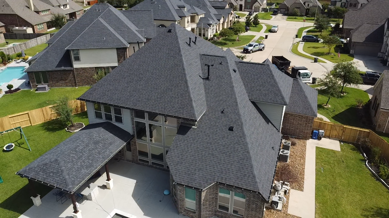 An aerial view of a large house in a residential area.